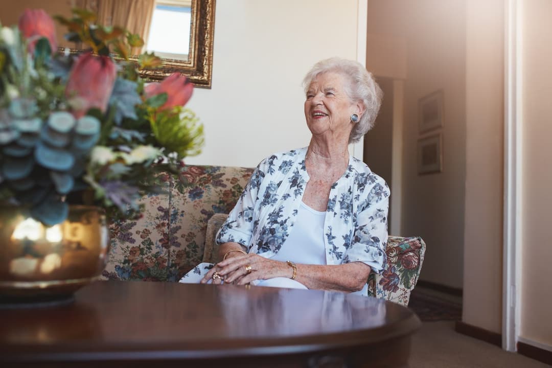 Smiling senior woman relaxing at home on the couch